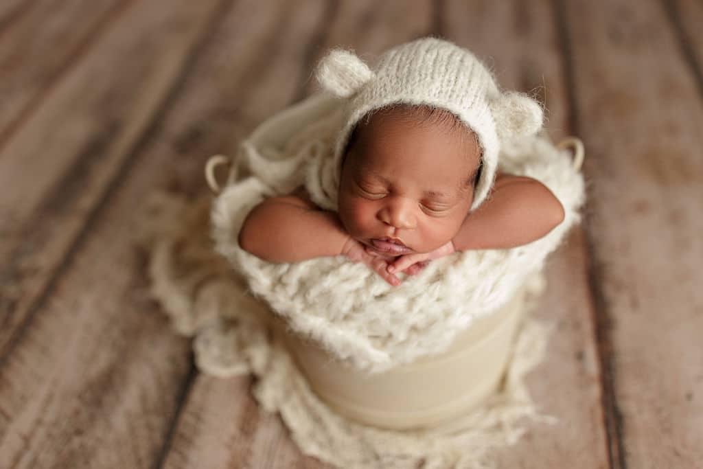 baby with a bear hat in a bucket