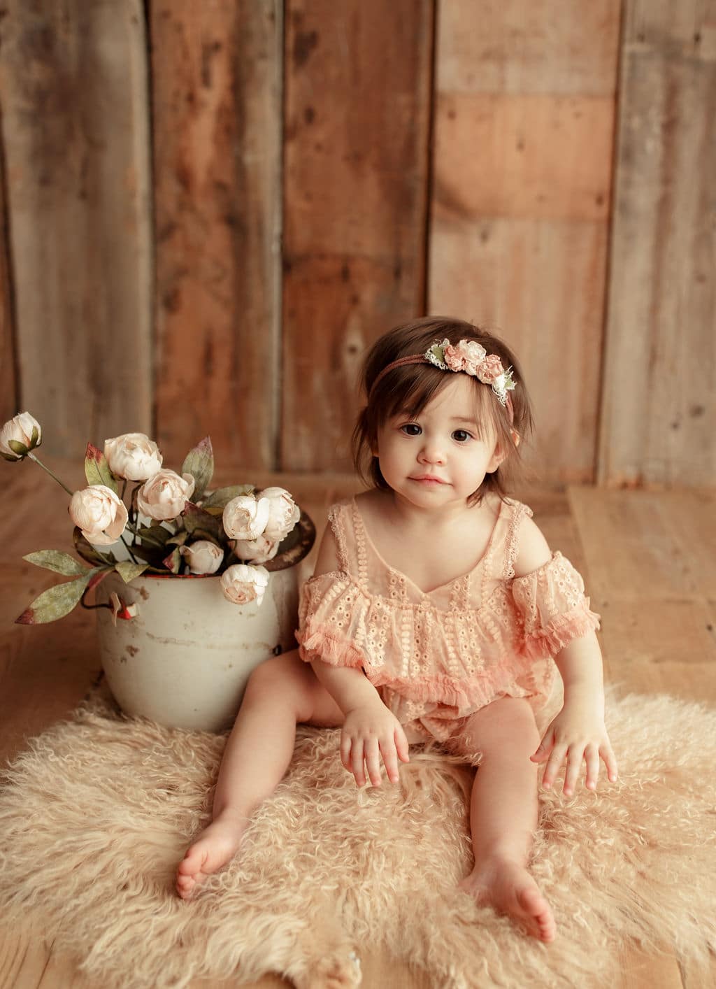 baby with a bucket of flowers 