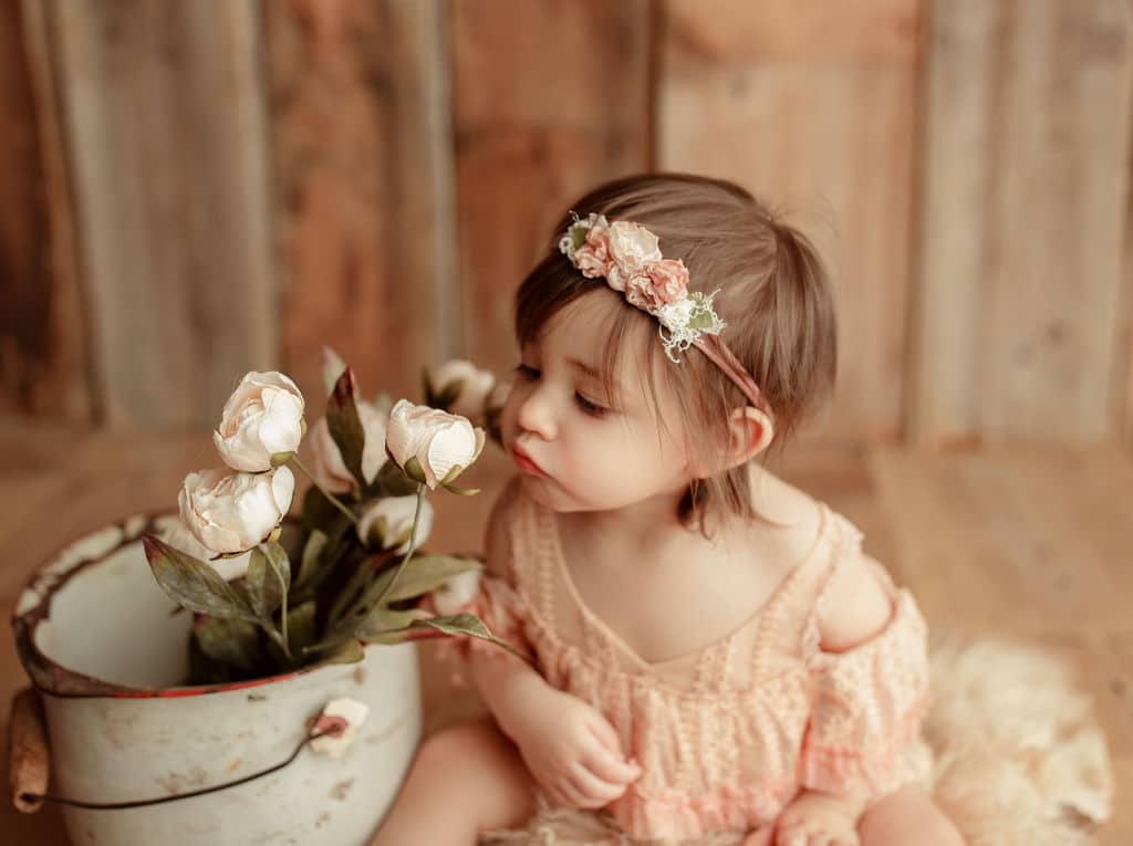 baby smelling flowers