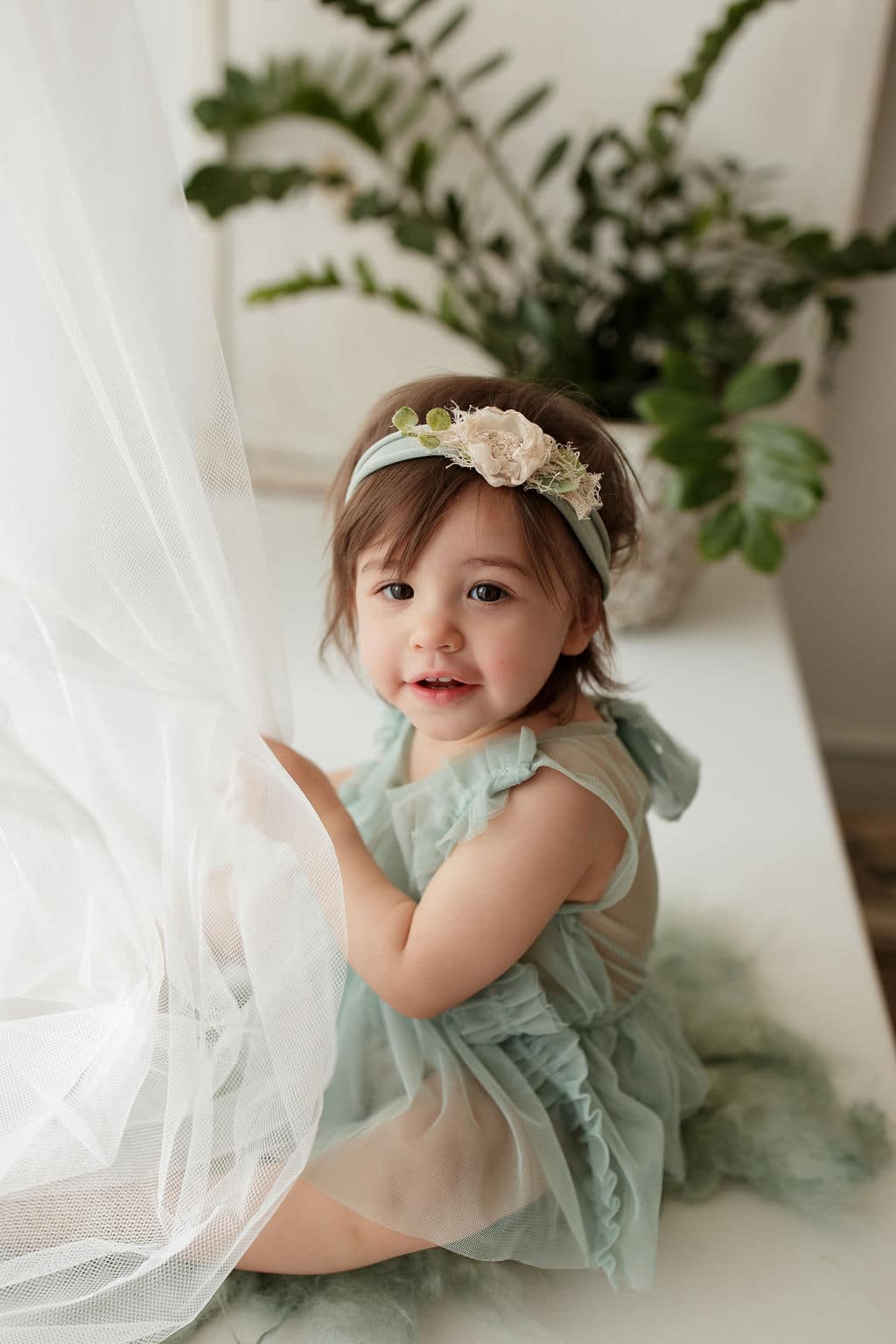 baby playing with curtains in Chicago studio