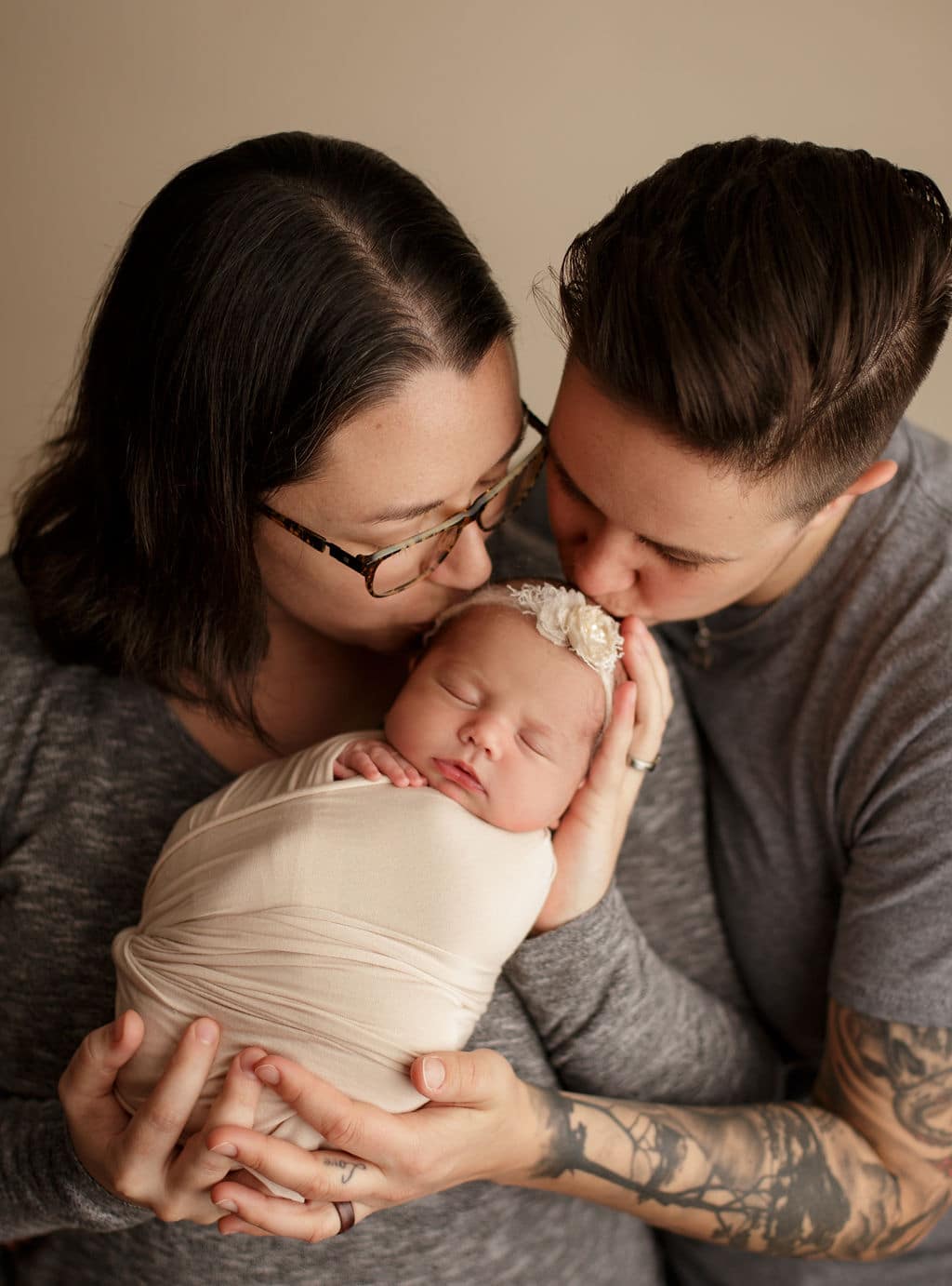 moms kissing newborn daughter