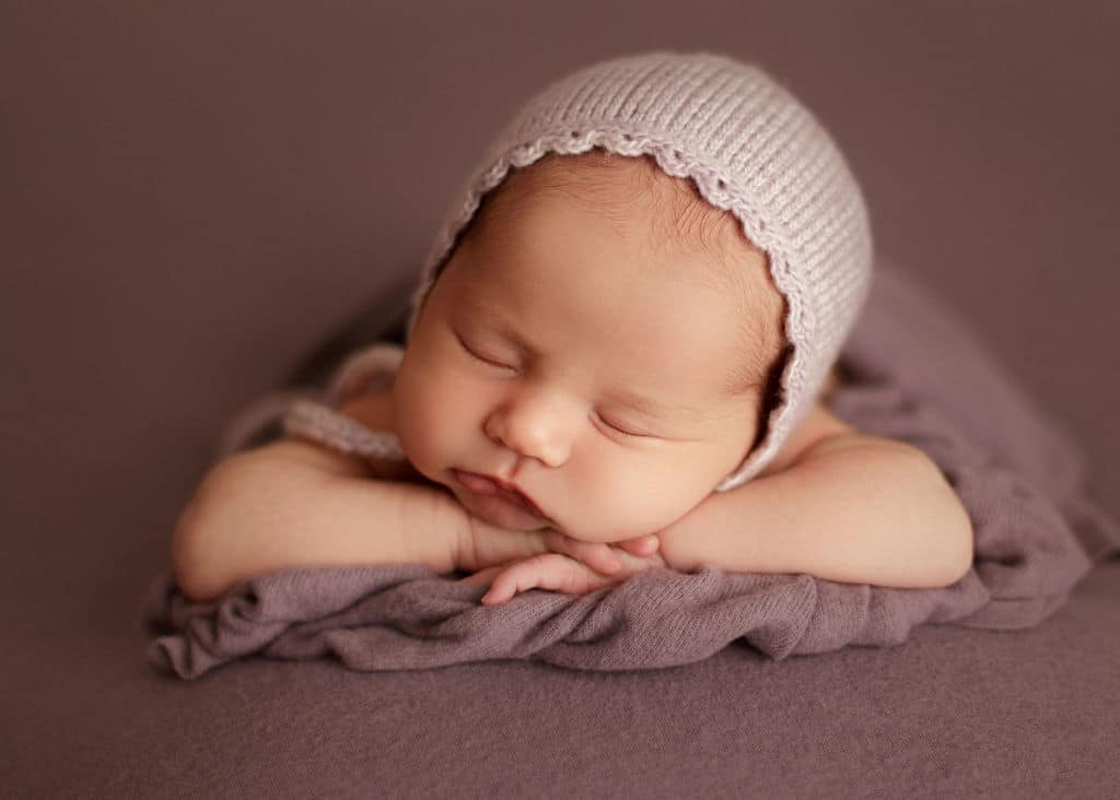 sleeping gorgeous newborn girl in purples