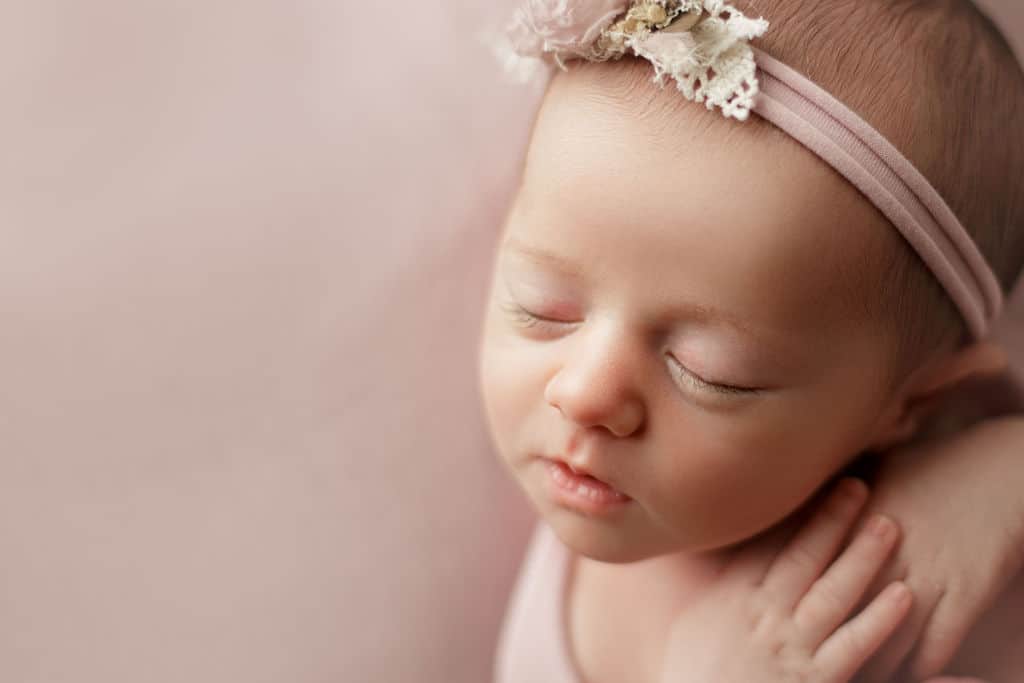 newborn girl on pink sleeping