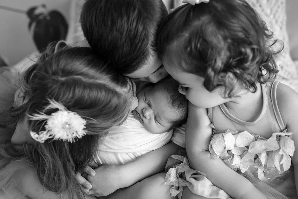 black and white photo siblings cuddling