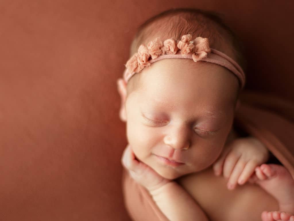 newborn baby girl with a little smile