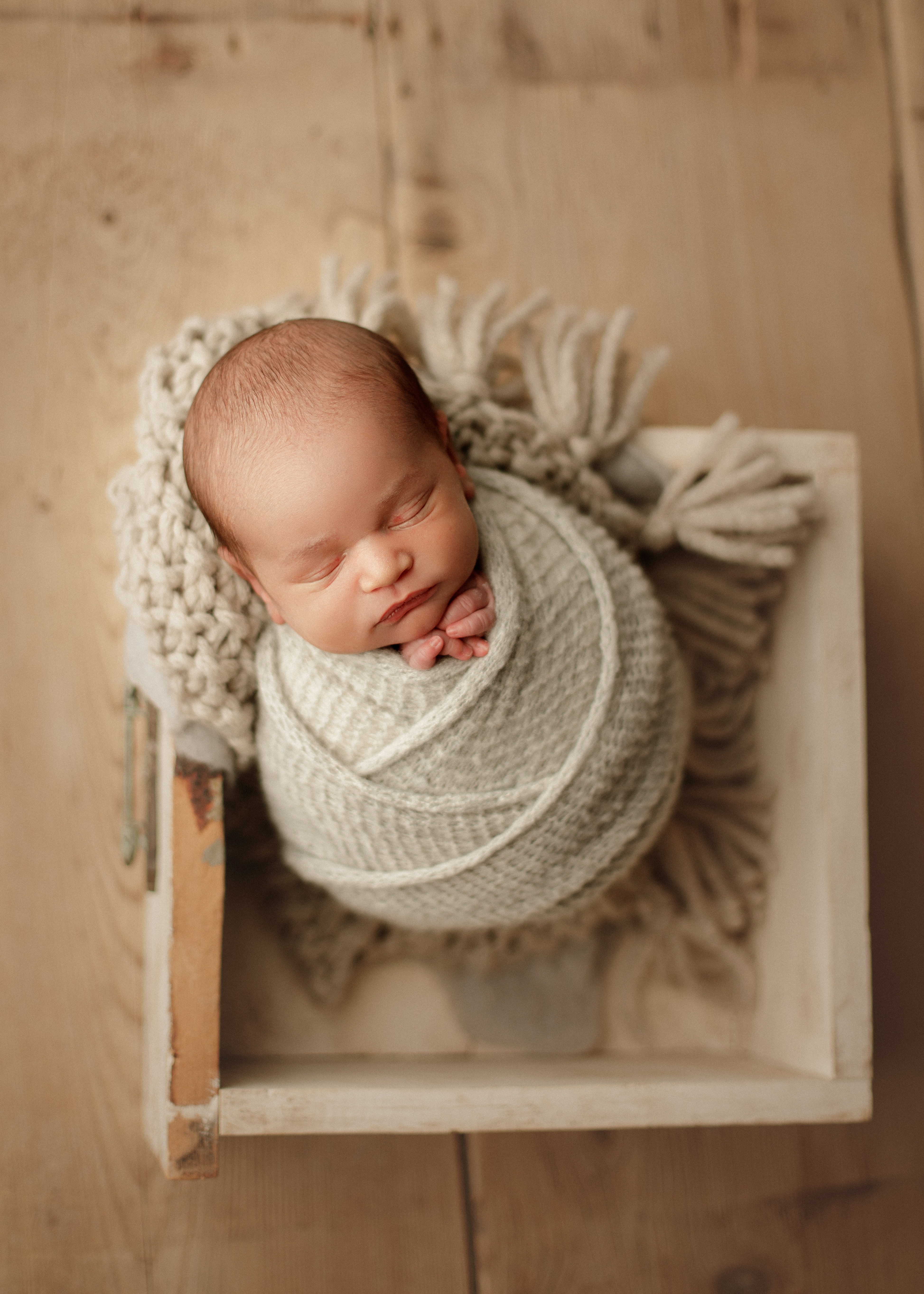 baby boy swaddled in a box at newborn session